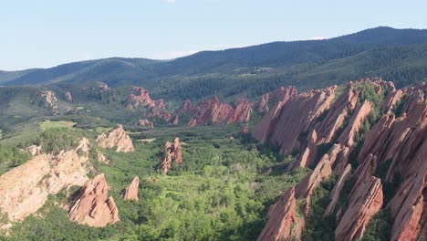 Beauty-of-nature,-drone-landscape-of-massive-rock-formations-in-contrast-to-lush-green-forest