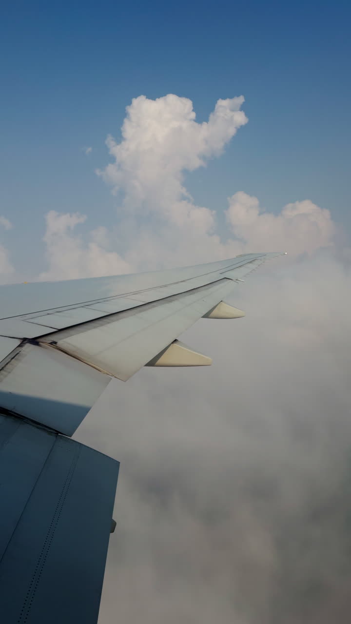 view from a plane window of the sky with the wing shot in vertical
