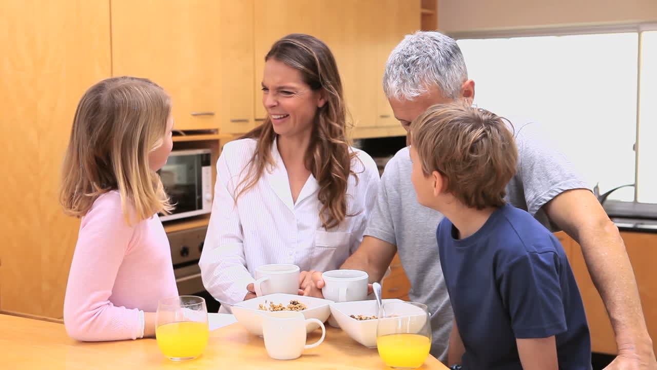 행복 한 가족 이 아침 식사 를 하고 있다