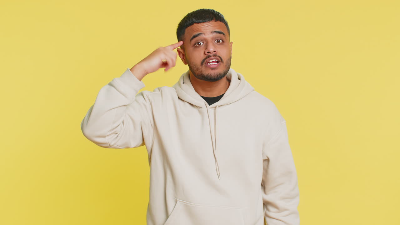 Confused indian man pointing at camera showing stupid asking for insane crazy bad plan bullying