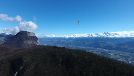 hombre en parapente sobre los alpes franceses de grenoble vista aérea de un avión no tripulado