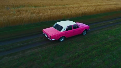 pink vintage car on a country road