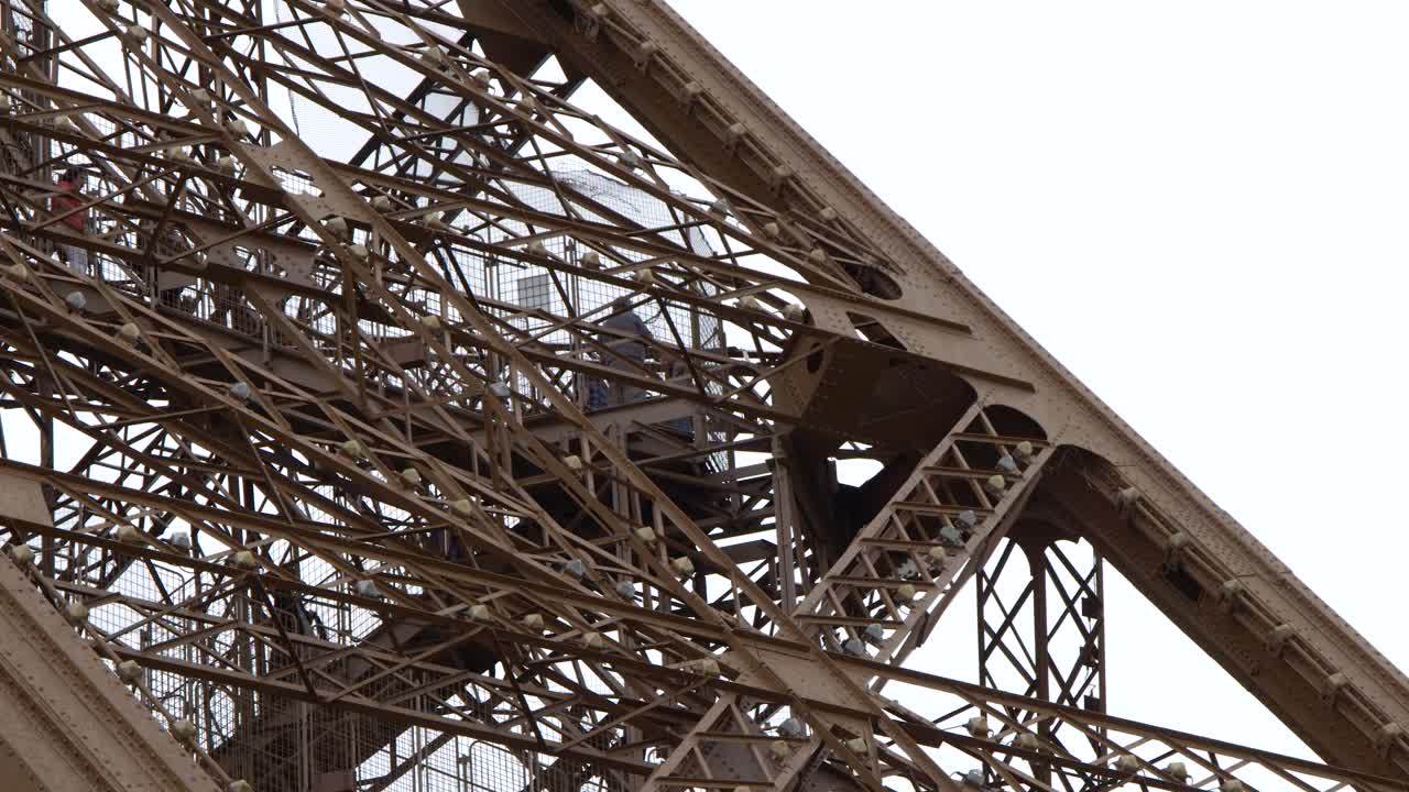 A detailed static shot captures the complex metal framework and architectural engineering of a landmark