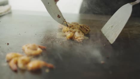 shrimp and meat stir fry cooked skillfully in hot stone grill - close up shot