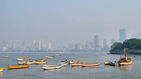 fisherman sailing the boat in arabian sea against mumbai city skyline