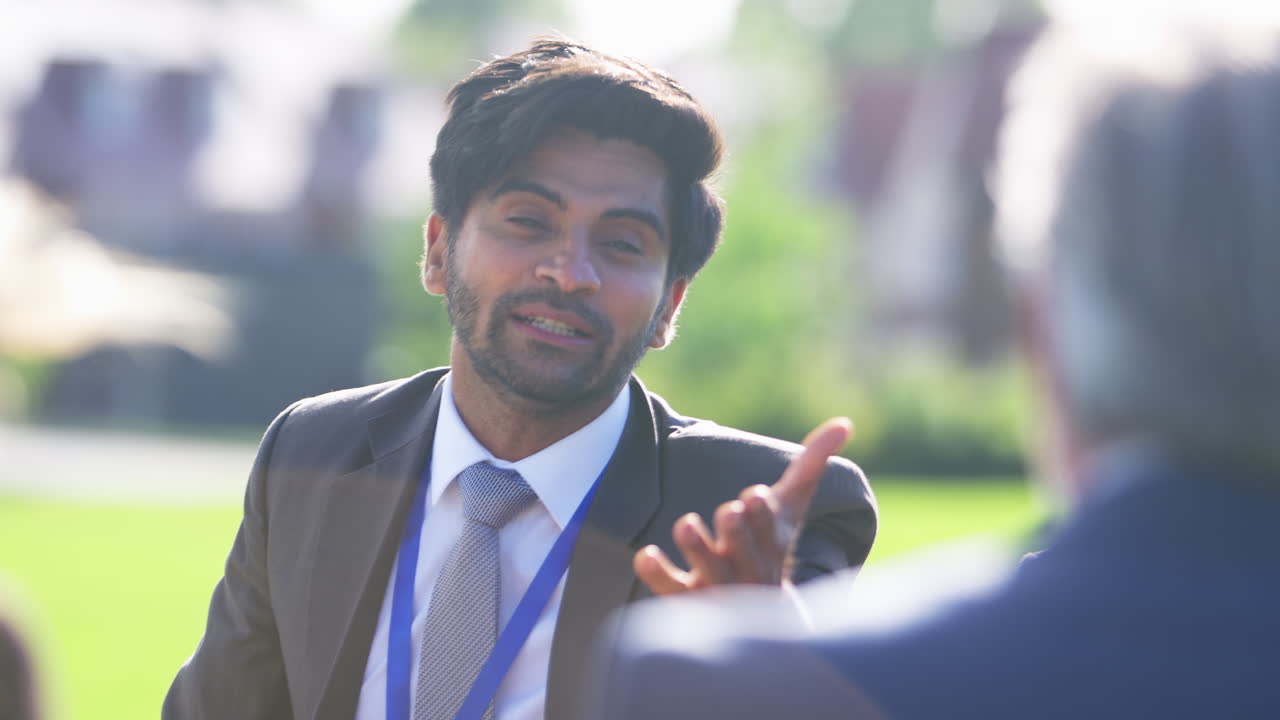 다문화 비즈니스 팀이 사무실 밖에서 커피 휴식을 취하고 비공식 회의를 하고 있습니다.