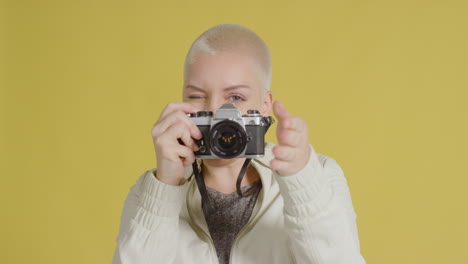 Female-caucasian-model-looking-into-camera-with-a-vintage-SLR-