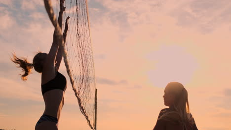 Gruppe-Junger-Mädchen,-Die-Beachvolleyball-Bei-Sonnenuntergang-Oder-Sonnenaufgang-In-Zeitlupe-Spielen.-Schöne-Mädchen-Im-Bikini-Spielen-Professionell-Volleyball-Auf-Dem-Sand