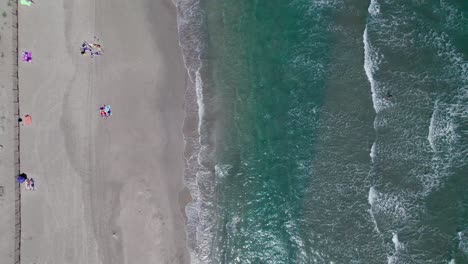 Vista-Aérea-De-Arriba-Hacia-Abajo-De-Los-Turistas-Disfrutando-De-Sus-Vacaciones-En-La-Playa-En-La-Grande-Motte,-Francia