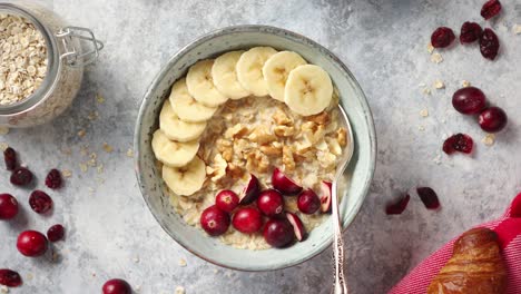 cuenco de cerámica de gachas de avena con plátano, arándanos frescos y nueces