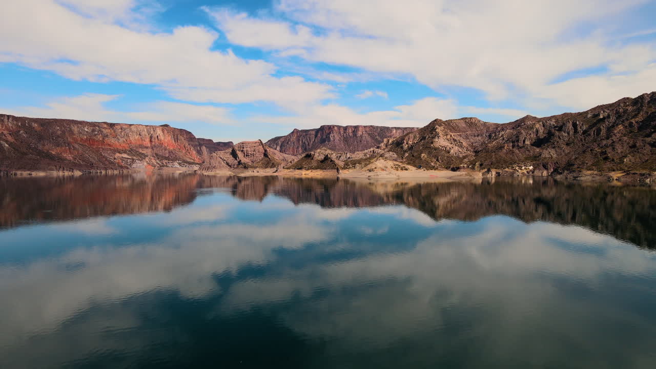 imagen de avión no tripulado capturando montañas y una laguna cristalina