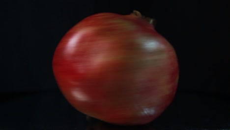 pomegranate in fast rotation on black background