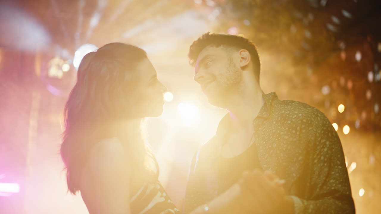 Primer plano de una pareja bailando junta con luces de discoteca. Pareja romántica moviéndose