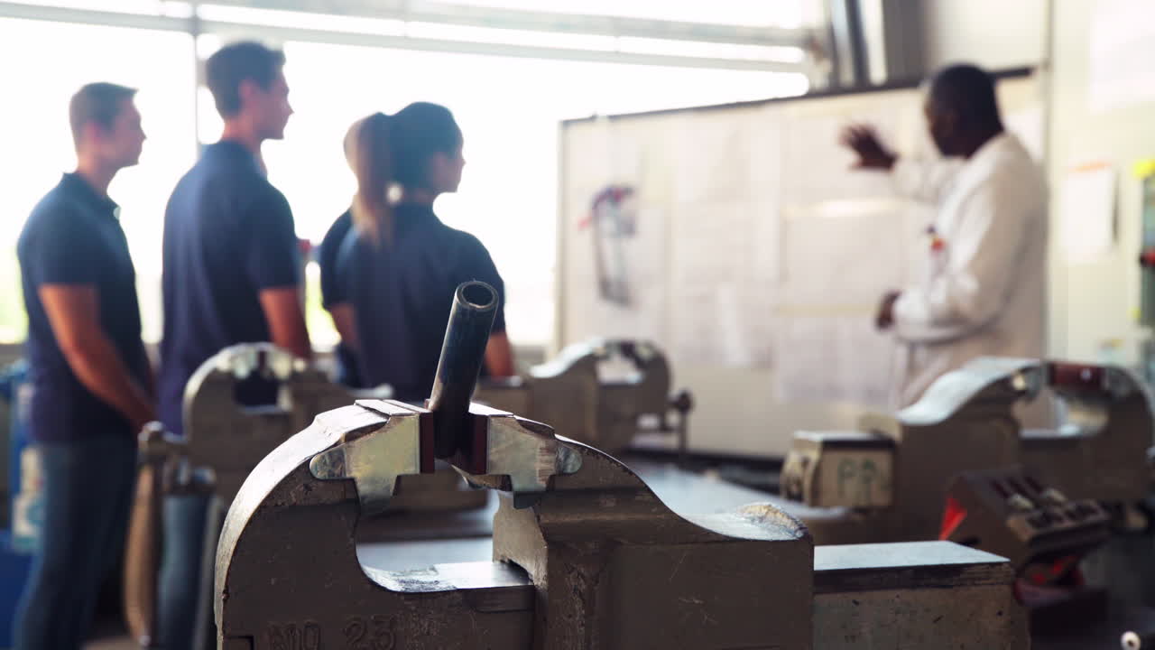 grupo de aprendices ingenieros escuchando al tutor en clase