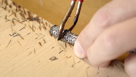 craftsman cutting off piece of silver color bracelet before adding clasps