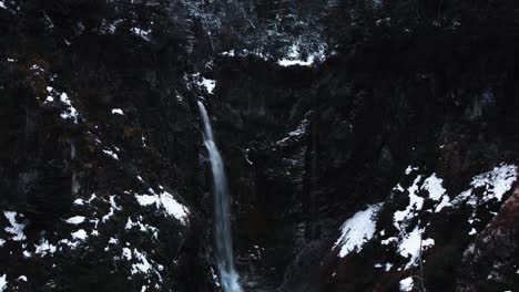 Toma-Aérea-De-Una-Cascada-Rodeada-De-Montañas-Y-Nieve-De-Un-Paisaje-En-La-Patagonia-Argentina