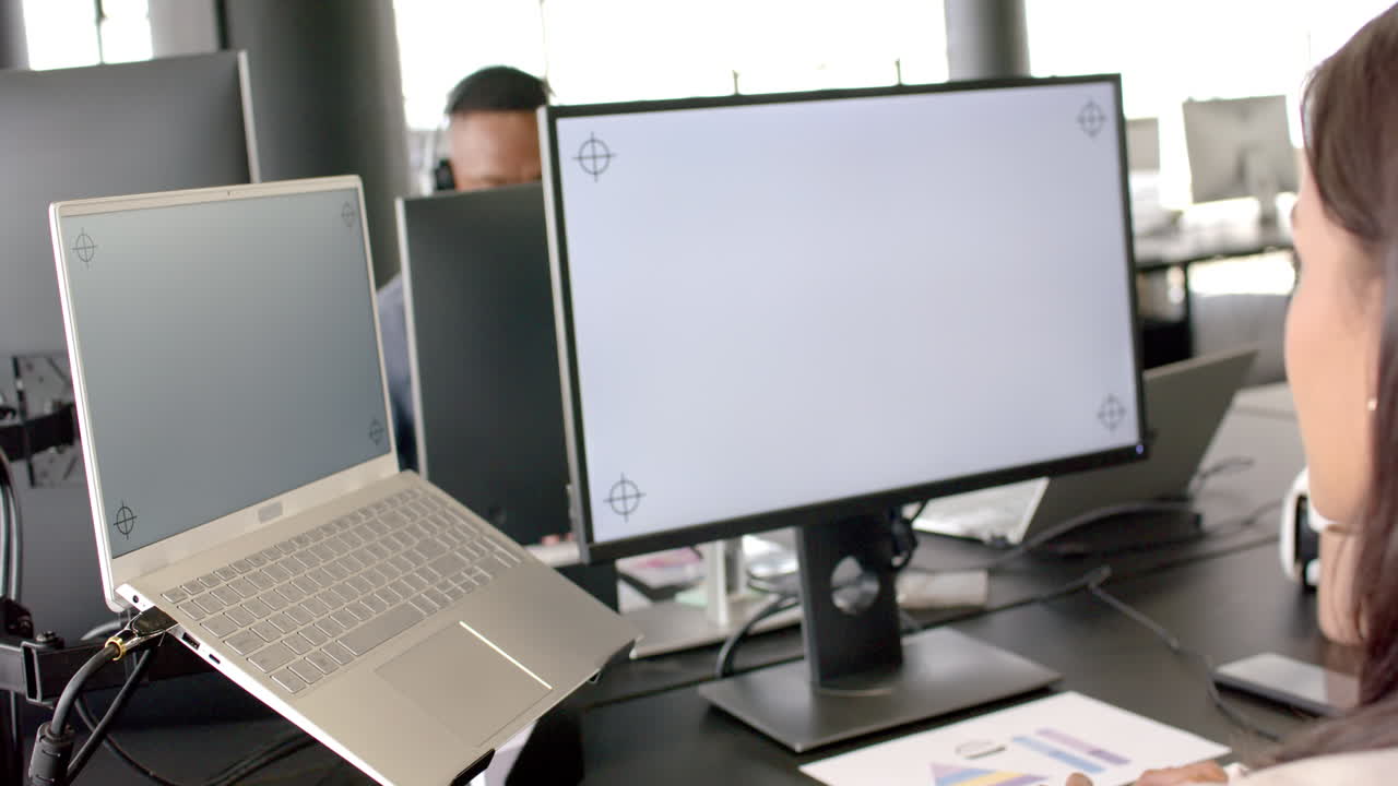 Working in office, person using laptop and desktop monitor for business tasks, copy space