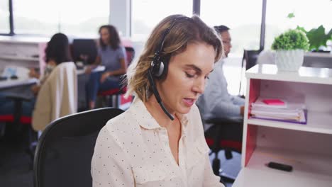 Professional-businesswoman-talking-on-phone-headset-in-modern-office-in-slow-motion