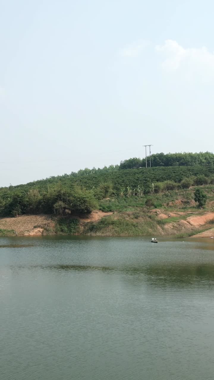 Scenic view of a lake with a green hill