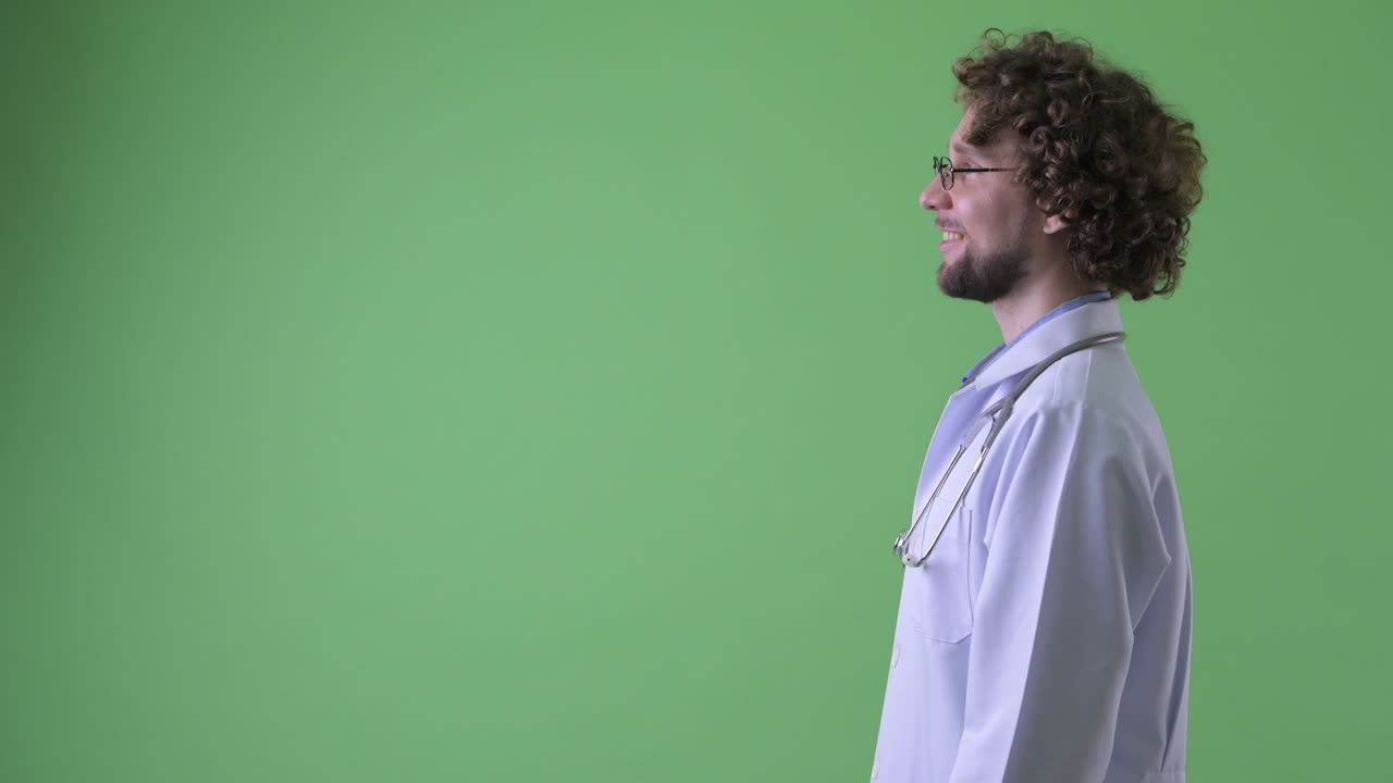 Young handsome bearded man doctor with curly hair