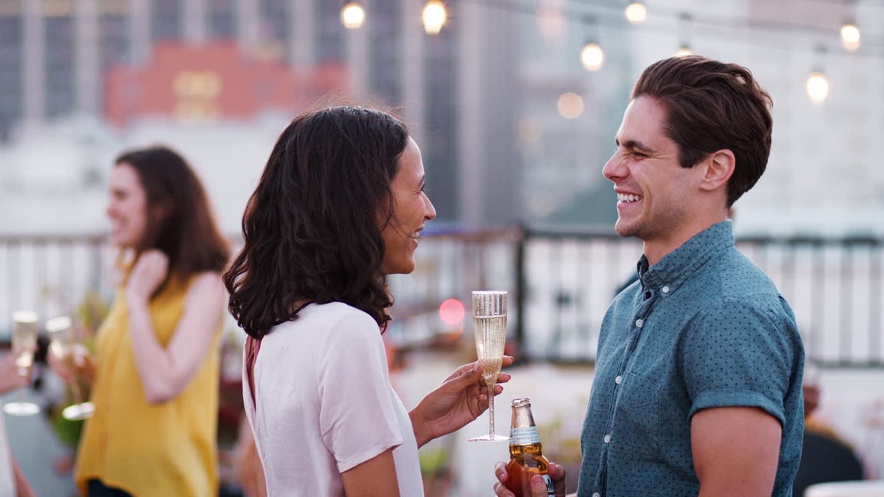 amigos reunidos en la terraza del techo para una fiesta con el horizonte de la ciudad en el fondo