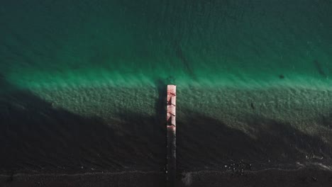 birds eye view of empty wooden dock on a lake with turquoise water