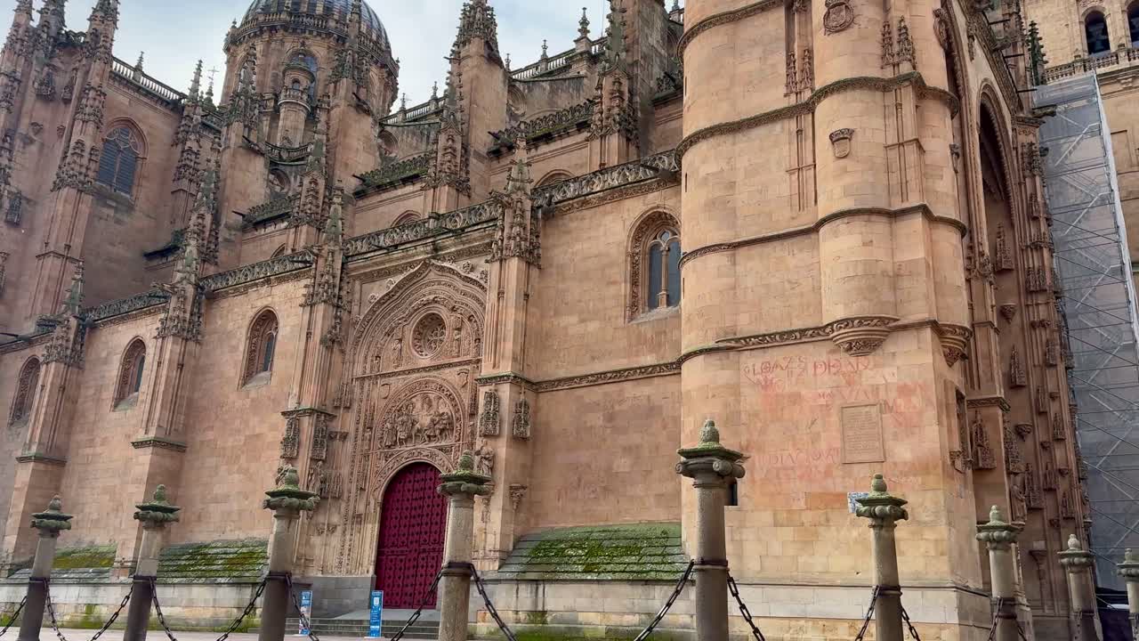Historic Segovia Cathedral entrance with intricate stonework and red door.