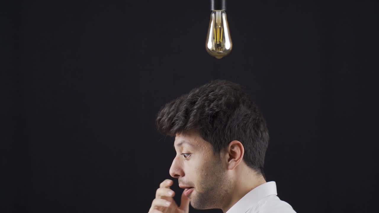 Young Man With An Idea. A light bulb is burning above his head.