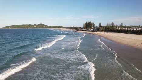 belongil beach with waves splashing on the shore in byron bay, nsw, australia - drone shot