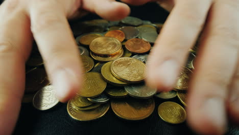 manos para tomar un montón de monedas de la mesa