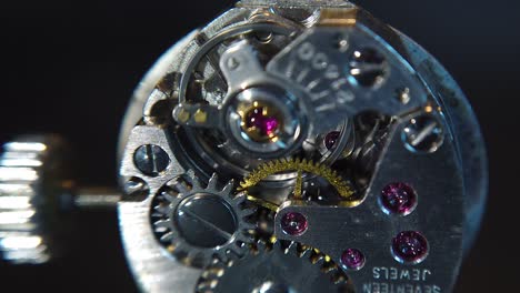 a detailed, zoom in shot of the rotating gears inside the wristwatch