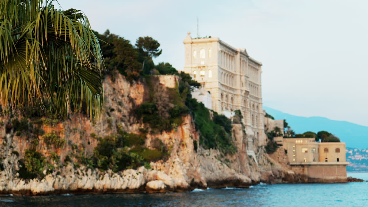 View of the The Oceanographic Museum of Monaco on the shore with the mountains on the background