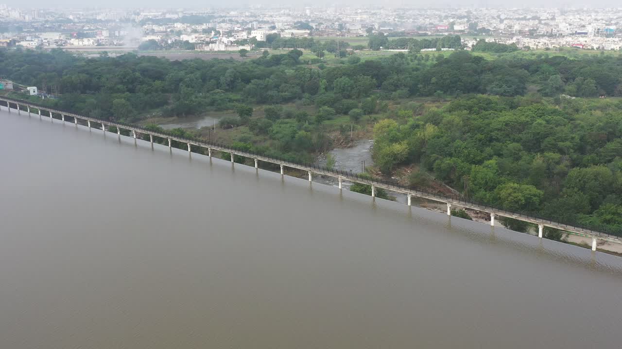 Aerial View of a Dam and Reservoir Near a City