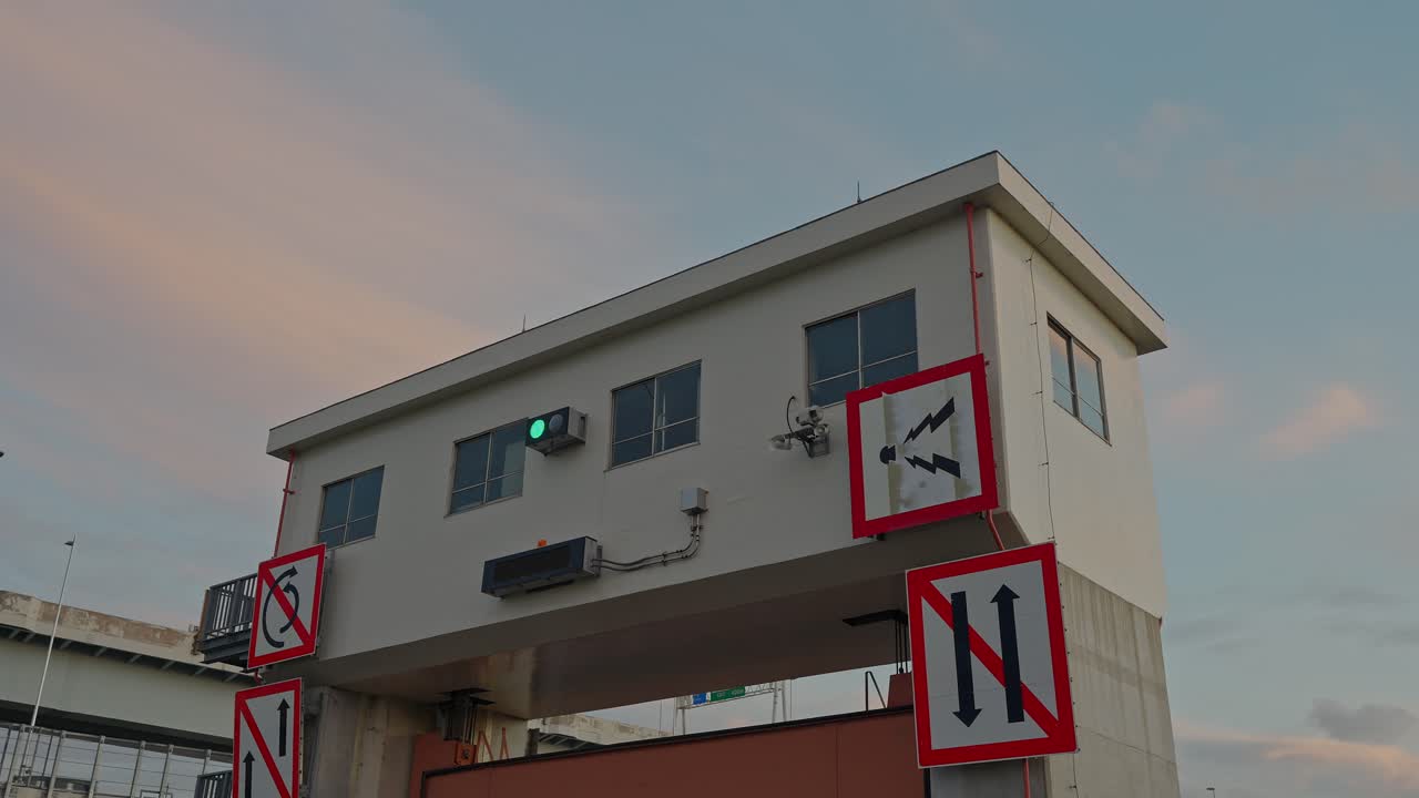 A straight-on shot of the control building of the Sumida Sluice Gate with various warning signs