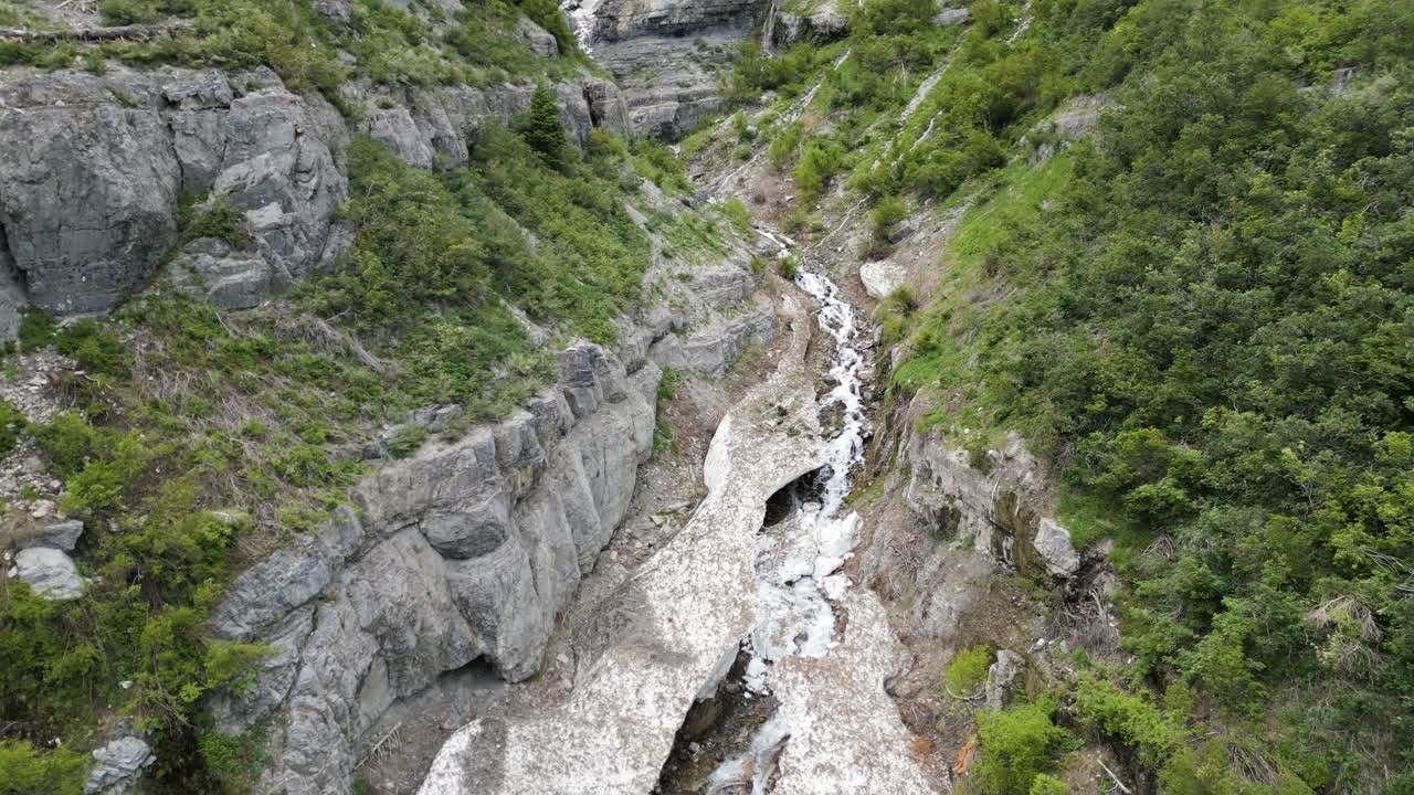 estableciendo una vista aérea para revelar las cuevas de hielo de utah lecho del río en las laderas glaciales de provo woodland valley