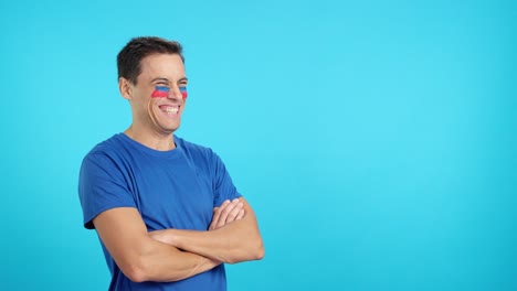 Happy man with haitian flag painted on face looking away