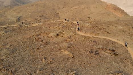 group of filipino mountain bikers cycling downhill enduro on the al taween trail of shawka-showka, ras al khaimah, united arab emirates