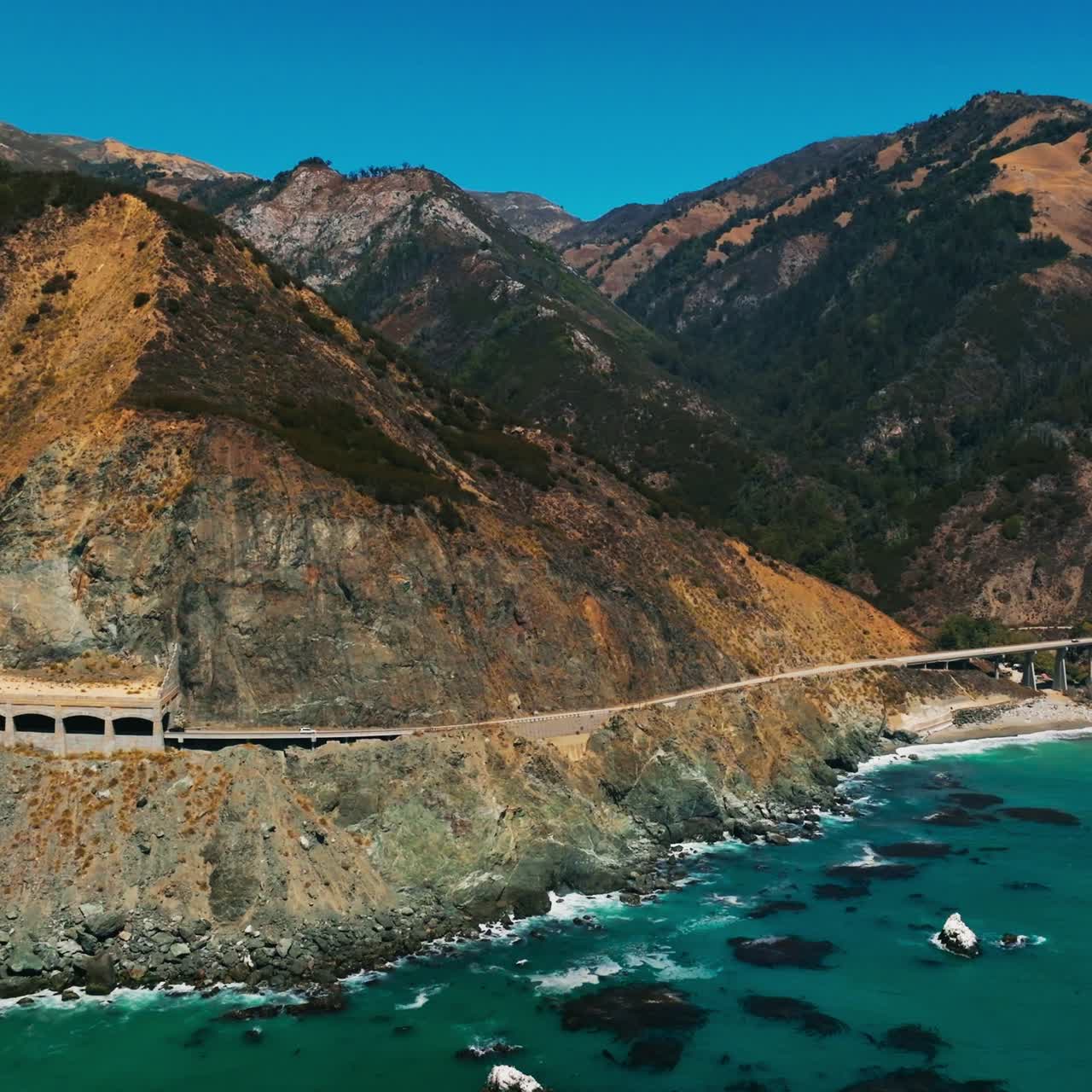 Car driving under the Rock Shed on California. Travelling pacific road highway