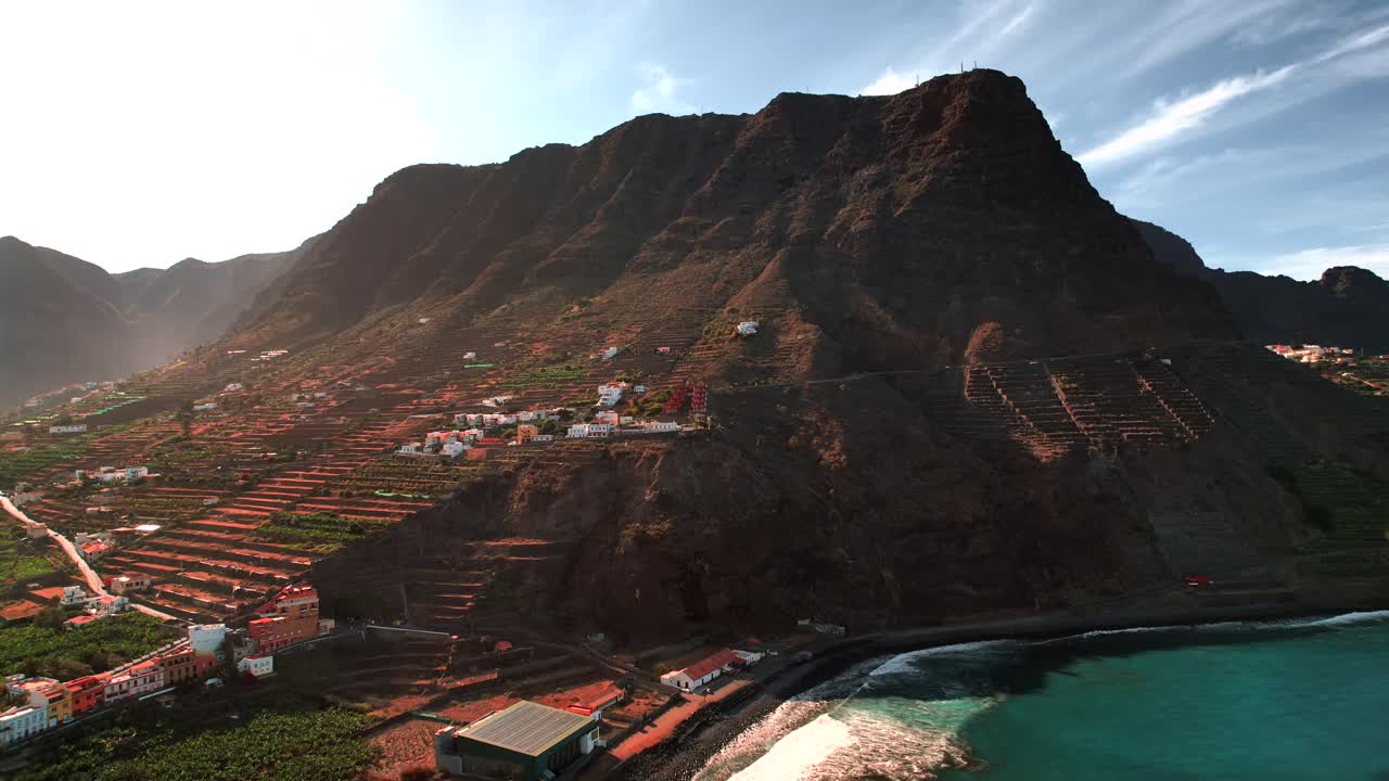 Vista aérea de un valle de montaña en terrazas con un pueblo en la ladera, Islas Canarias.