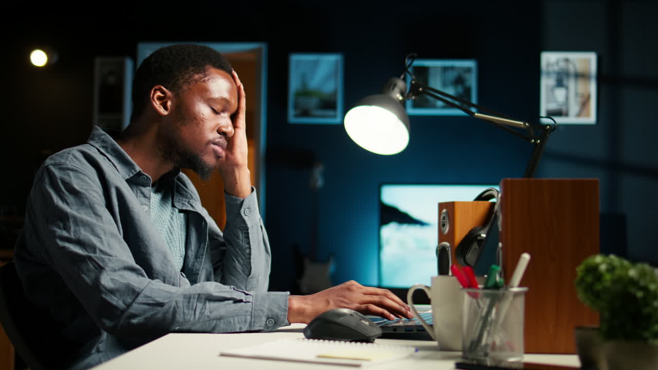 Self employed person feeling fatigued and stressed at home desk