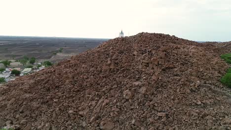 Aerial-zoom-in-view-of-Small-temple-on-top-of-the-Rock-boulder-Hill-or-mountain