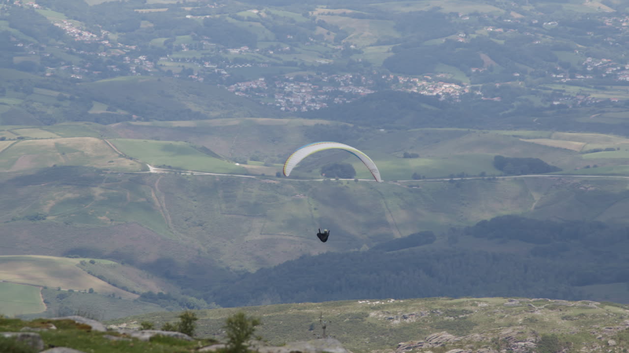 산 의 계곡 을 가로질러 패러글라이딩