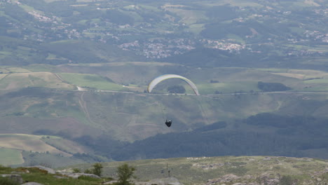 en parapente sobre un valle en las montañas