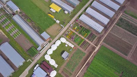 aerial view of a large agricultural facility with greenhouses and gardens