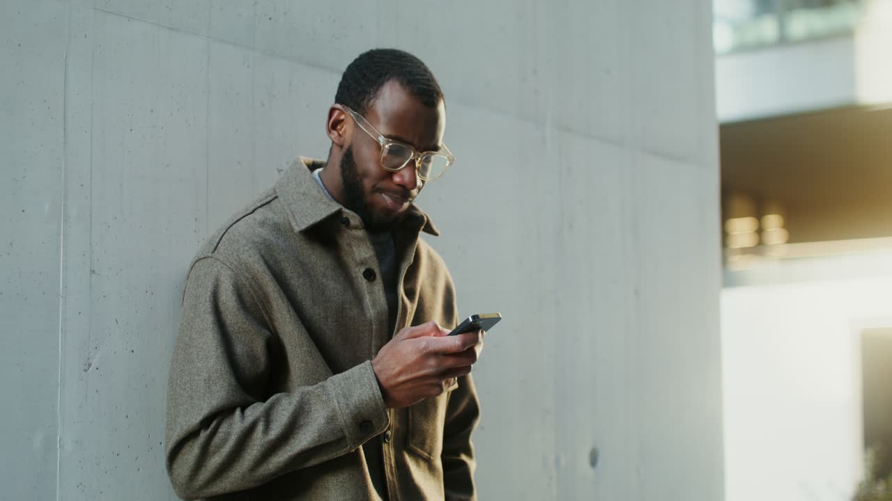 Uomo che manda messaggi sullo smartphone all'aperto