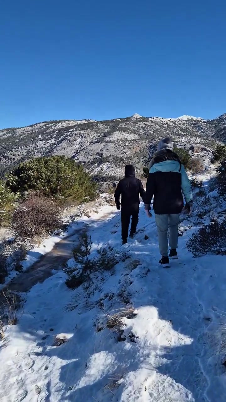 Due persone che fanno escursioni su un sentiero di montagna innevato