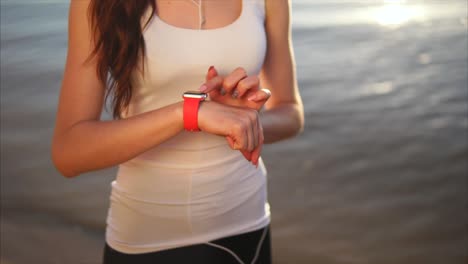 woman checking smartwatch on beach