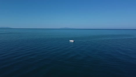 Drone-over-fishing-boat-in-Tuscany,-Italy-at-a-sandy-beach-at-the-seaside-near-Alberese-in-the-iconic-Maremma-nature-park-by-sunset