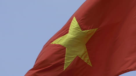 video 4k de la bandera nacional de vietnam bajo un sol brillante con cielo azul y fondo de nubes