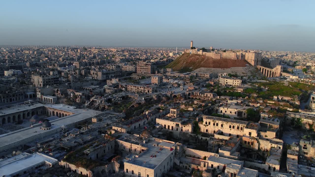 Vista aerea della cittadella di Aleppo al tramonto. Si può ammirare la città siriana che si estende su tutto l'orizzonte 4K